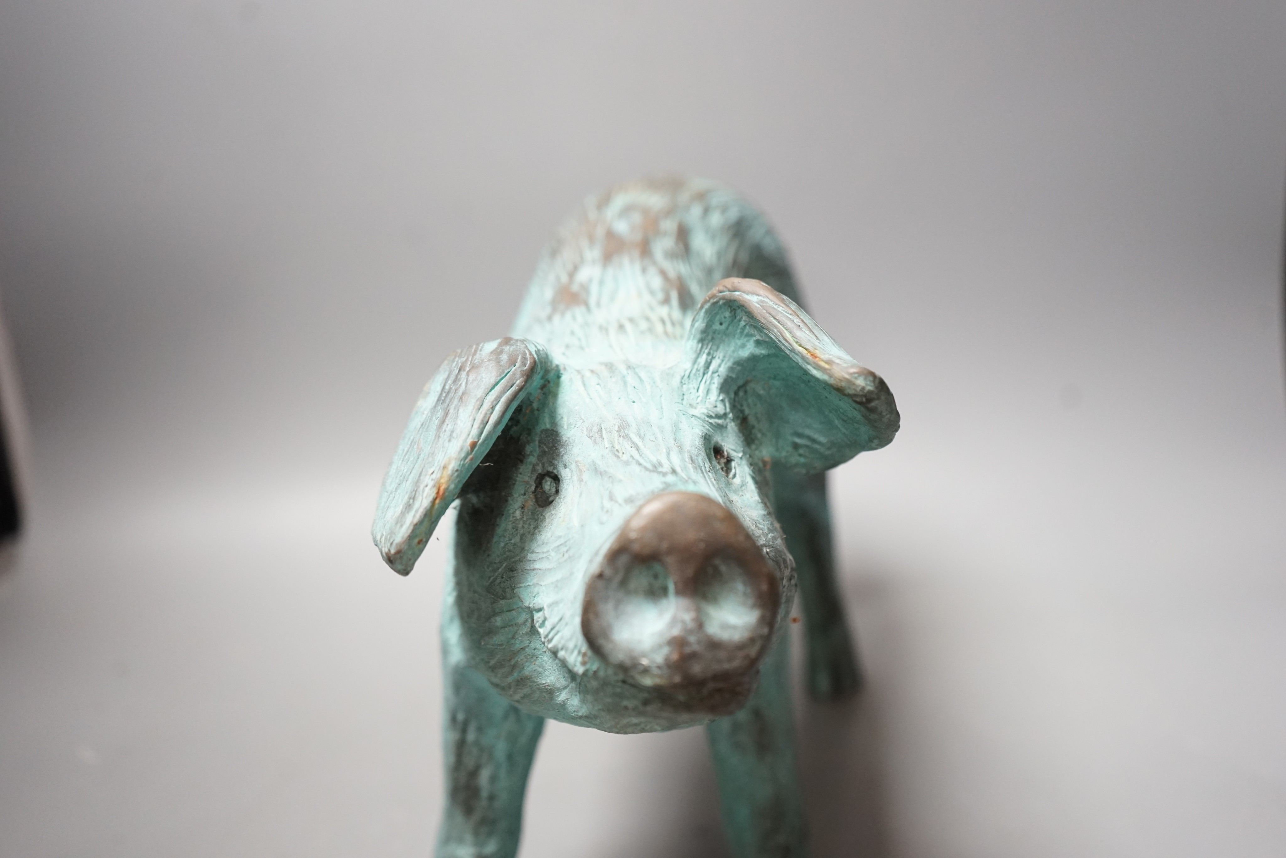 A cold cast resin bronze pig initialled 'JP', 40cm wide